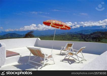 Deck chairs with a patio umbrella on a terrace