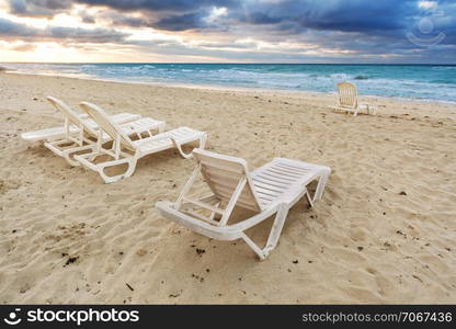 deckchairs on a beach on a background of ocean