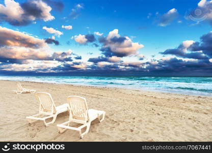 deckchairs on a beach on a background of ocean