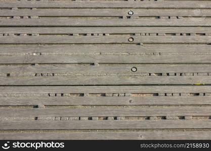 Decking made of old bolted wooden battens. Remains of old cement between the slats. Background. Background With Old Boards and Cement