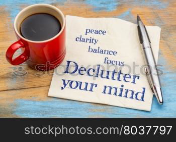 Declutter your mind for clarity, peace, focus and balance - handwriting on a napkin with a cup of espresso coffee