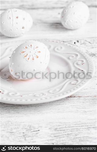 decor carved eggs. Decorative carved chicken egg for Easter to light the plate.Photograph high key.