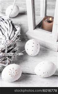 decor of carved eggs. Easter eggs with cut out pattern by hand on light background.The photograph high key.