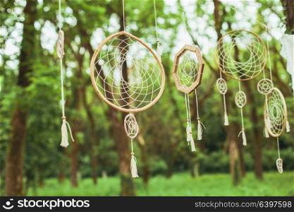 Decor with dream-catchers on a green forest background. Dream catcher decor