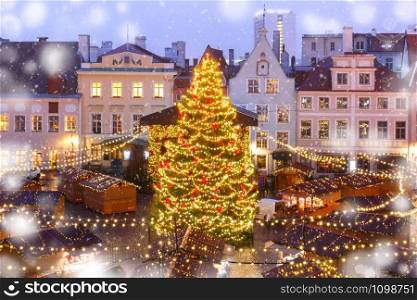 Decorated and illuminated Christmas tree and Christmas Market at Town Hall Square or Raekoja plats, Tallinn, Estonia. Aerial view. Christmas Market in Tallinn, Estonia