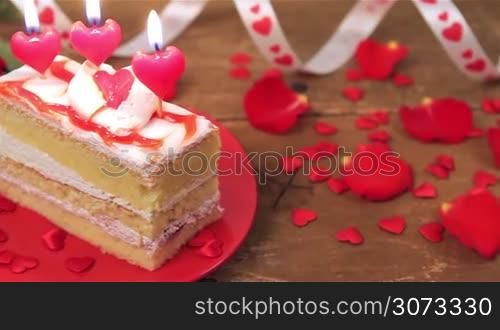 Decorated cake with candles and roses on wooden table for Valentine&acute;s Day. Love and romance concept.
