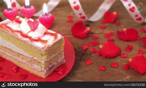 Decorated cake with candles and roses on wooden table for Valentine&acute;s Day. Love and romance concept.