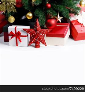 Decorated Christmas gifts and star under tree with baubles isolated on white background. Christmas gifts under the tree