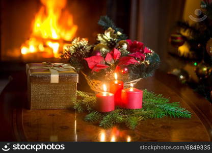 Decorated Christmas table at living room with burning fireplace