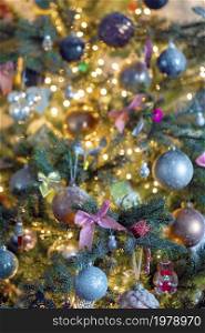 Decorated Christmas tree close-up with sparkling baubles and bokeh christmas lights, pink bow and glitter balls, copy space space for text. Decorated Christmas tree close-up with sparkling baubles and bokeh christmas lights, pink bow and glitter balls, copy space