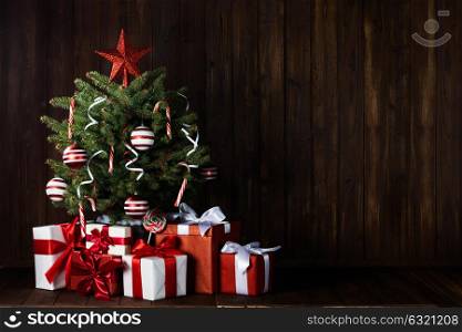 Decorated Christmas tree. Decorated Christmas tree with gift boxes on wooden background