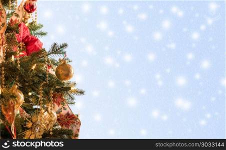 Decorated christmas tree in hero header format. Ornately decorated christmas tree with snowing blue background for copy space for holiday message. Decorated christmas tree in hero header format