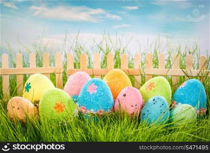 Decorated easter eggs in the grass on blue sky background