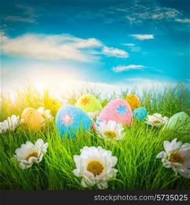 Decorated easter eggs in the grass on blue sky background