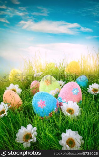 Decorated easter eggs in the grass on blue sky background