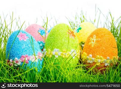 Decorated easter eggs in the grass on white background