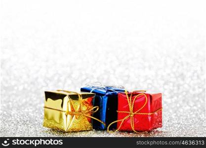 Decorated holiday gifts on silver background
