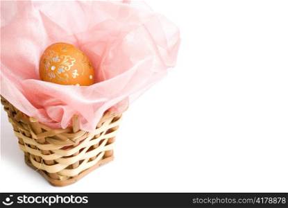 decorated orange easter egg in wooden handmade basket