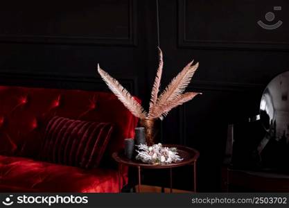 decorated room with a red velvet sofa and a vase on the table.. decorated room with a red velvet sofa and a vase on the table
