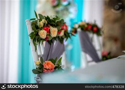 Decorated wedding chair with bouquet of roses. Bouquet of roses tied on chair in wedding party.