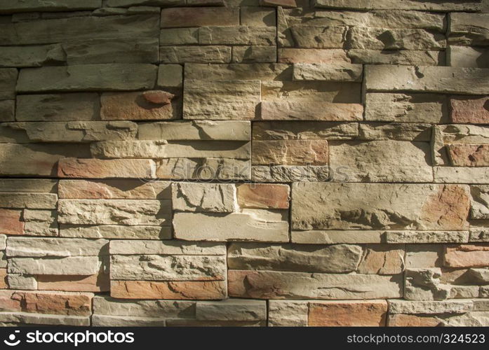 Decorated with beige stone on the wall The surface of the old stone wall is the background.