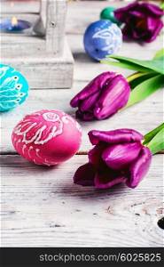 Decorated with painted Easter eggs and flowers on a light background. Painted Easter eggs
