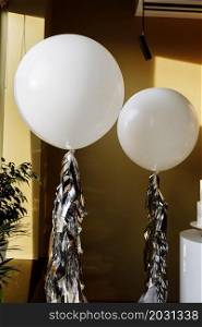 decoration for birthday with two big white balloons with tinsel. birthday party. selective focus. decoration for birthday with two big white balloons with tinsel. birthday party. selective focus.