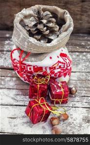 Decoration for Christmas holiday. Symbolic Christmas bag with pine cones and three gift boxes