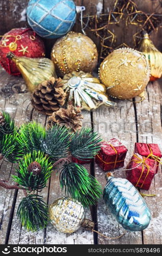 Decoration for the new year. Christmas decorations under the branches of fir tree on snowy wood plank