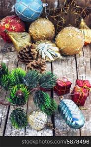 Decoration for the new year. Christmas decorations under the branches of fir tree on snowy wood plank