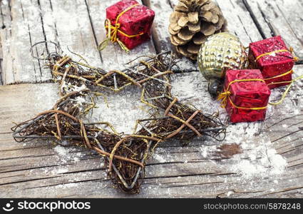 Decoration for the new year. Decorative Christmas star from a wire and decoration on wooden background