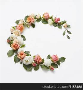 Decoration in the form of corner wreath from beautiful roses flowers with green leaves on a light grey background, copy space. Congratulation card for birthday.. Corner flowers crown from fresh natural roses and leaves.