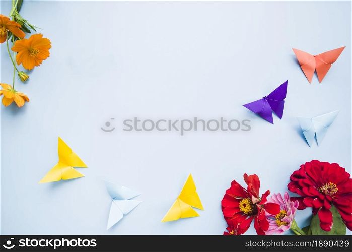 decoration with calendula marigold flowers origami paper butterflies blue background