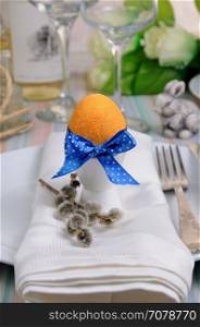 Decorations for Easter. Golden egg cups tied with a ribbon on a napkin.
