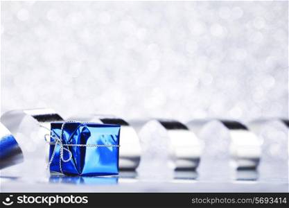 Decorative blue boxes with holiday gifts on shiny glitter background
