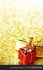Decorative boxes with holiday gifts on abstract gold background