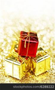 Decorative boxes with holiday gifts on abstract gold background