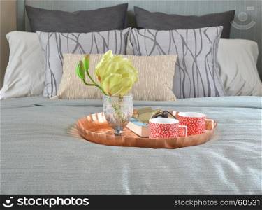 Decorative brass tray with glasses and sun glasses on bed