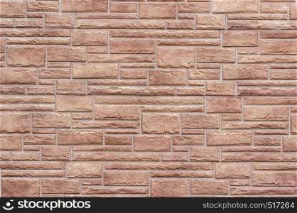 Decorative brick wall as background or texture. Artificial stone in the brown hues in geometric pattern.