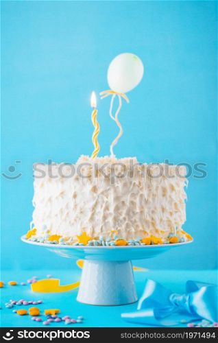 decorative cake illuminated candle blue backdrop. High resolution photo. decorative cake illuminated candle blue backdrop. High quality photo