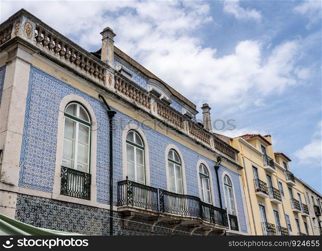 Decorative ceramic tiles on a large house with balconies in Alfama district of Lisbon, Portugal. Traditional ceramic tiles decorate exterior of large house in Lisbon