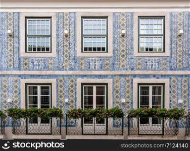 Decorative ceramic tiles on a large house with balconies in downtown Lisbon, Portugal. Traditional ceramic tiles decorate exterior of large house in Lisbon
