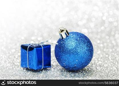 Decorative Christmas ball and gift on abstract glitter silver background