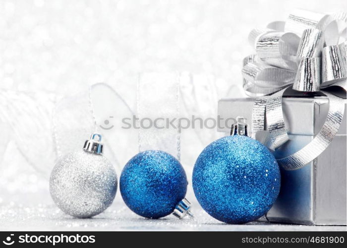 Decorative Christmas balls and gift on silver bokeh background