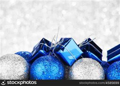 Decorative Christmas balls and gifts on abstract glitter silver background