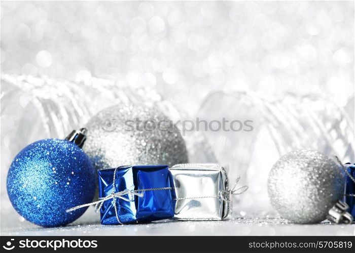 Decorative Christmas balls and gifts on silver bokeh background