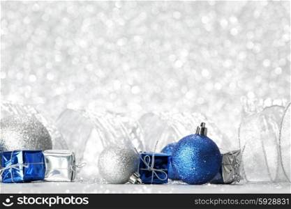 Decorative Christmas balls and gifts on silver bokeh background
