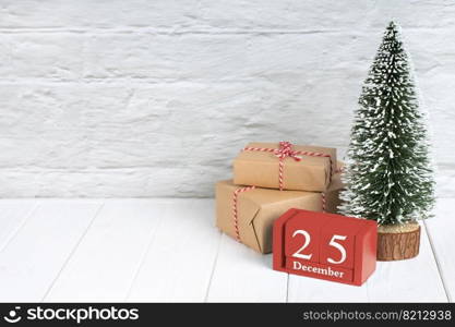 Decorative Christmas tree, gift boxes with in craft paper and red wooden perpertual calendar with date on white wooden background. Banner, header, New Year background with copy space. Decorative christmas tree, gift boxes and wooden calendar on white wooden background.