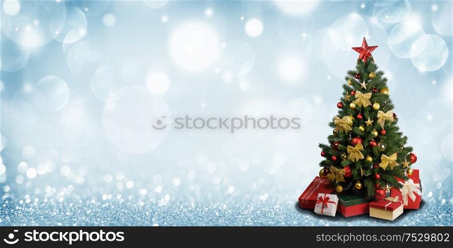 Decorative Christmas Tree over blue glitter background with copy space. Christmas Tree on glitters