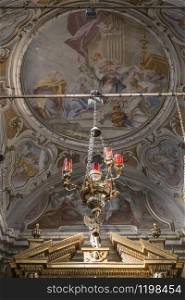 Decorative church lamp against the background of the ancient ceiling painting of the church. Monte Isola. Italy